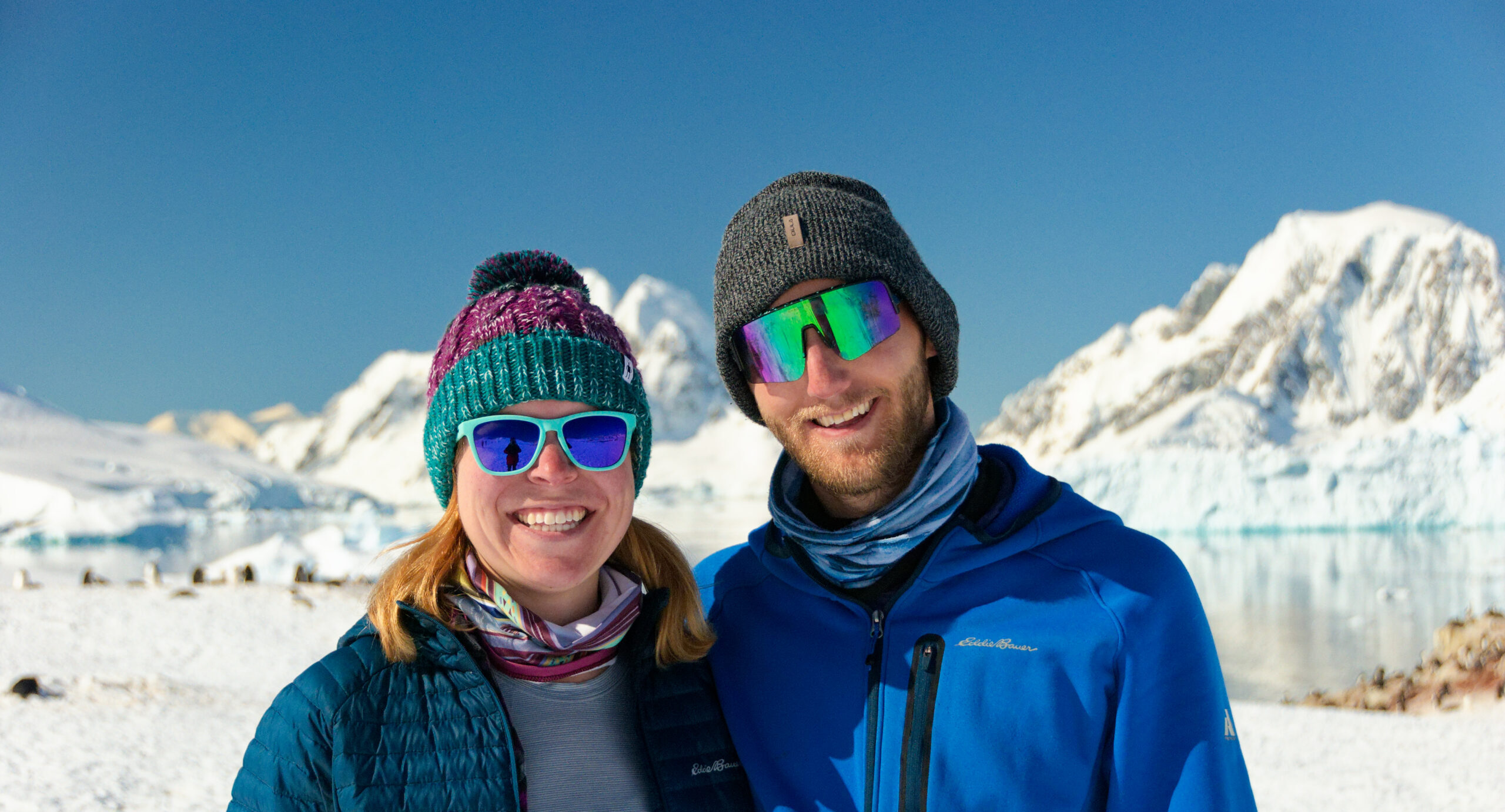 two people in front of snowy mountains