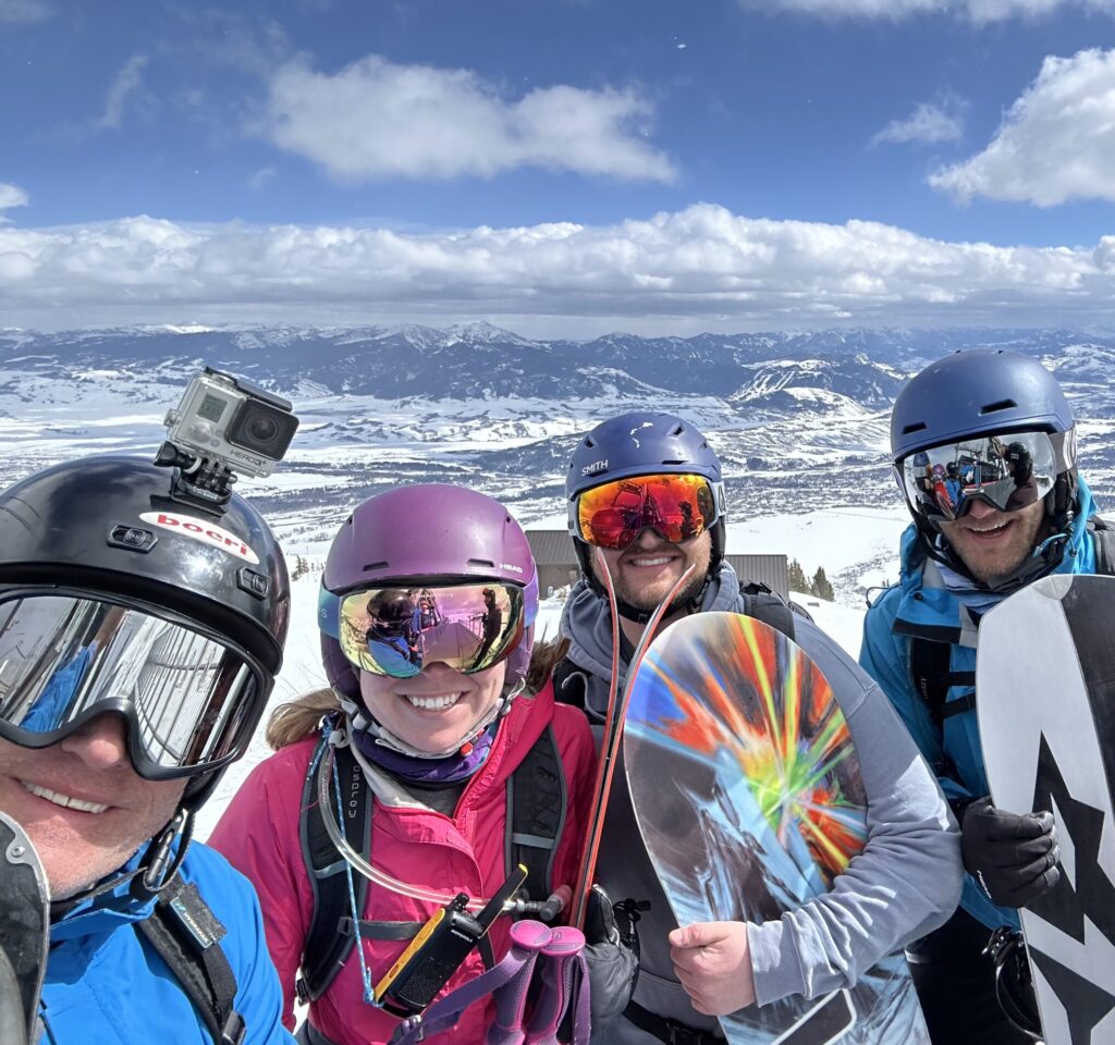 group of 4 people with ski gear and snowboards