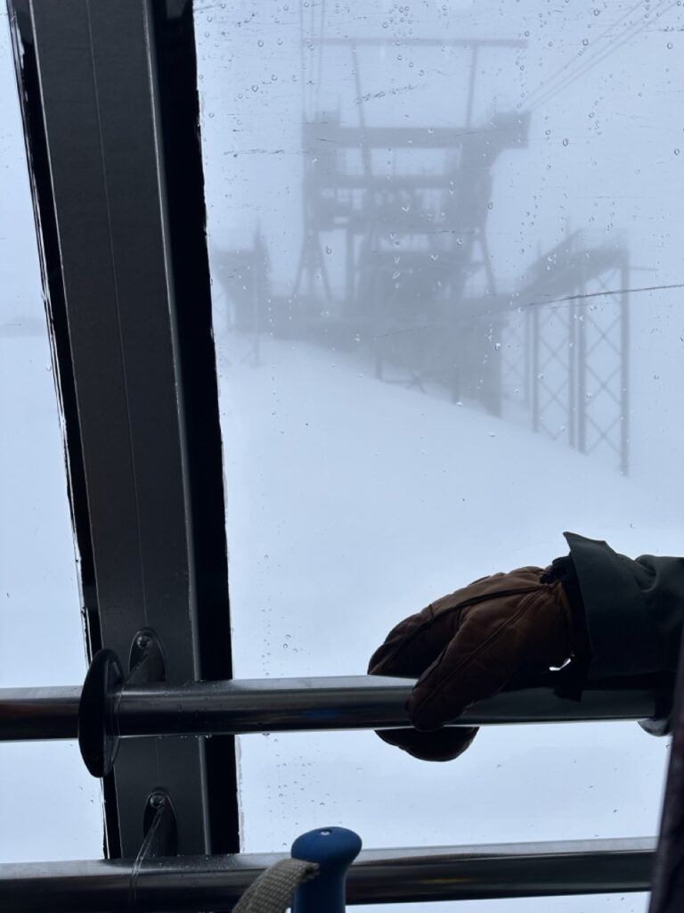 skier staring out the dark and gloomy tram to the top of jackson hole