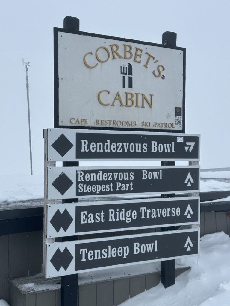 Corbets cabin sign with multiple ski trail markers