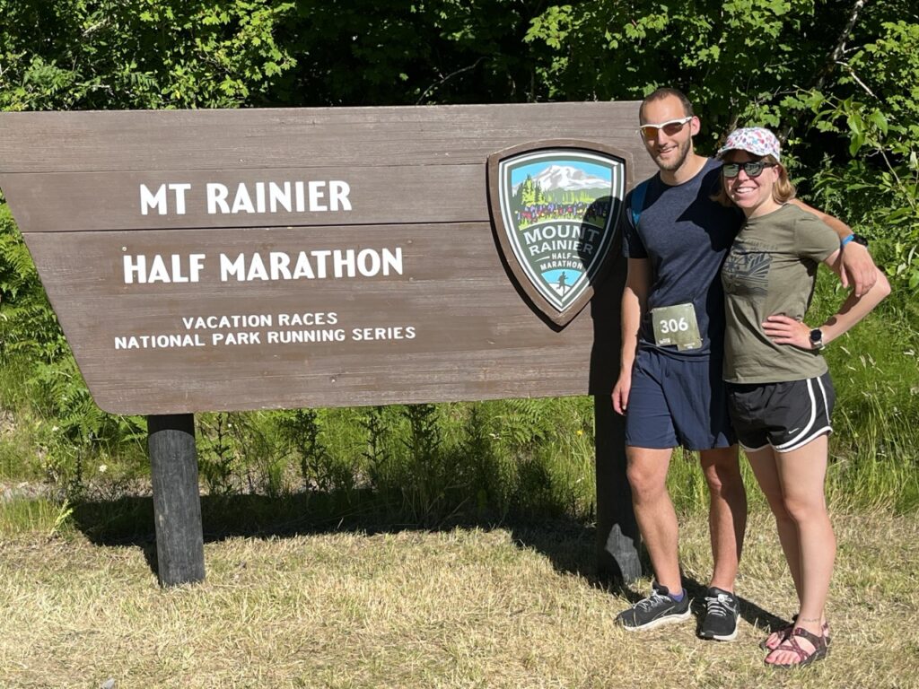 Jake and Emmali standing next to Mount Rainier Half Marathon sign