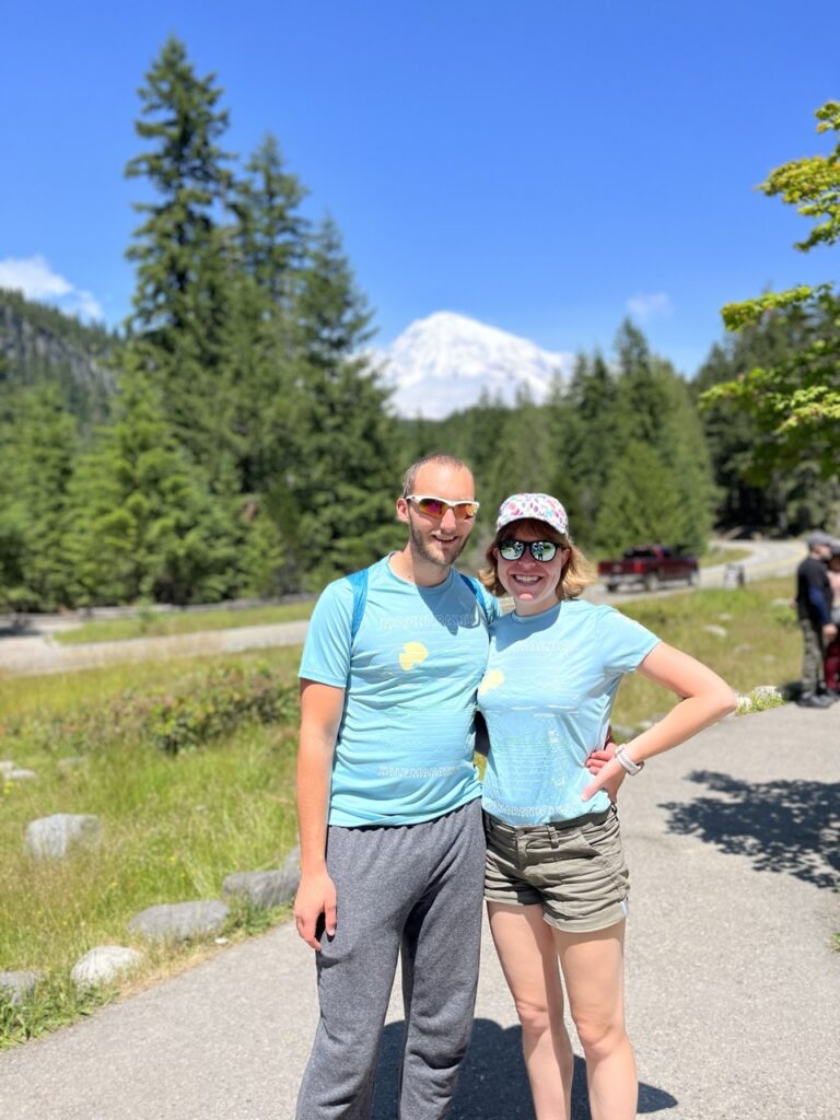 Jake and Emmali standing in the foreground with Mount Rainier in the background